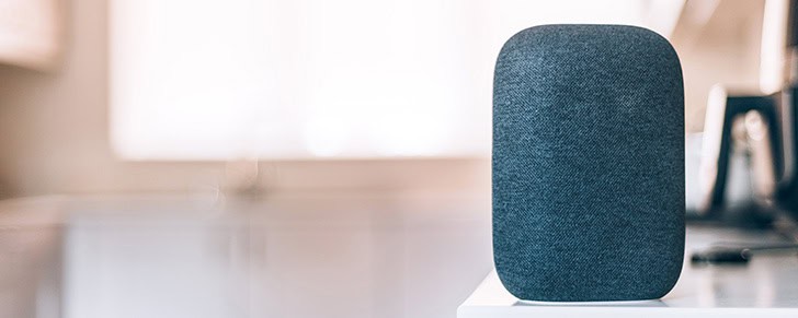 A voice controlled smart speaker sitting on a desk
