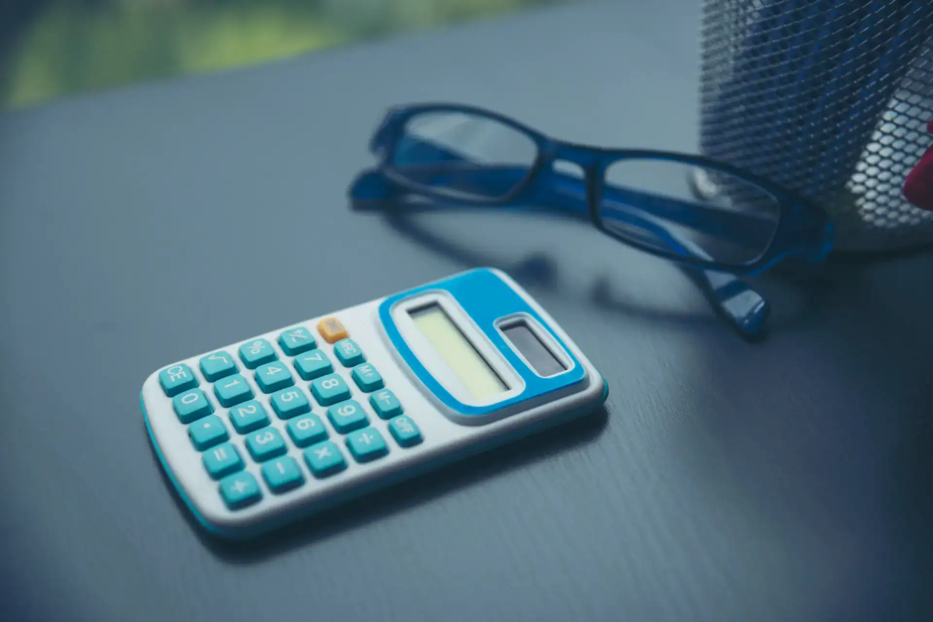 Calculator and eyeglasses on office desk