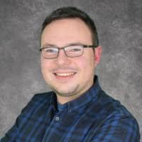 Smiling man wearing glasses and blue plaid shirt